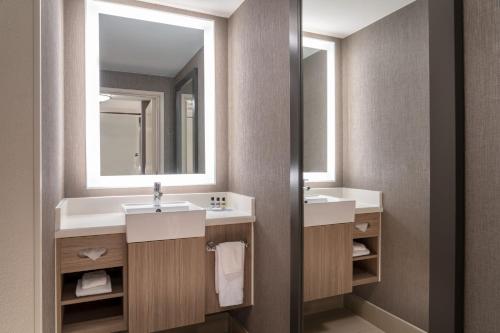 a bathroom with two sinks and a mirror at SpringHill Suites West Mifflin in West Mifflin