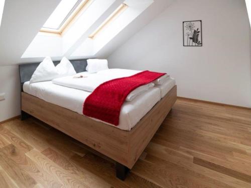 a bedroom with a bed with a red blanket on it at Flat in Hohentauern near the ski area in Hohentauern