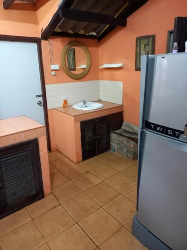 a kitchen with a sink and a refrigerator at Teak house Chiang Mai in Chiang Mai