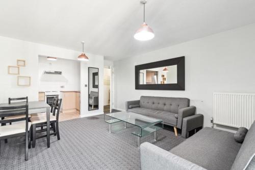 un soggiorno con divano e tavolo di Docklands Cozy View Apartment a Londra