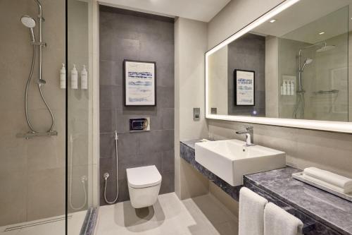 La salle de bains est pourvue d'un lavabo, de toilettes et d'une douche. dans l'établissement Courtyard by Marriott Jubail, à Al-Jubayl
