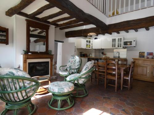 - un salon avec des chaises, une table et une cheminée dans l'établissement Élégante maison rénovée en campagne, proche de Dreux et Chartres, avec 2 chambres accueillantes. - FR-1-581-103, à Garnay