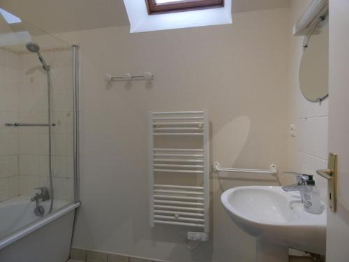 ein weißes Bad mit einem Waschbecken und einer Dusche in der Unterkunft Gîte Trizay-Coutretot-Saint-Serge, 4 pièces, 5 personnes - FR-1-581-67 in Trizay-Coutretot-Saint-Serge