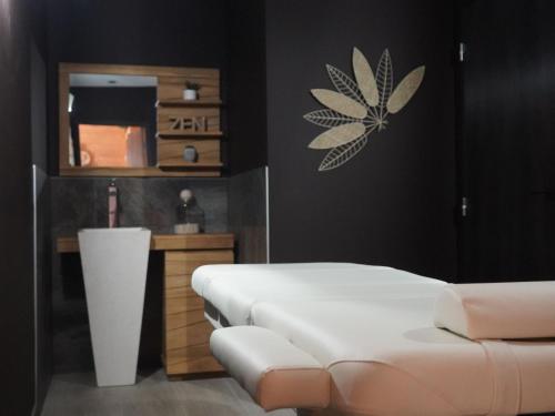 a bedroom with a white bed and a mirror at Lodge avec bain à remous privatif, piscine, salle de sport et aire de jeux au bord du golf de Chambon - FR-1-582-370 in Le Chambon-sur-Lignon