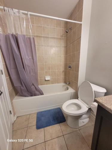 a bathroom with a toilet and a tub and a sink at Private Room 2 in Ottawa