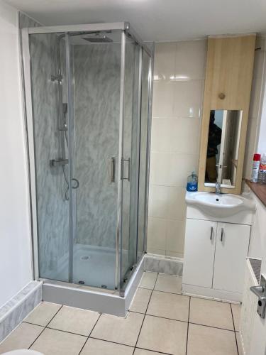 a bathroom with a glass shower and a sink at Transformative housing Exeter Road in Nottingham