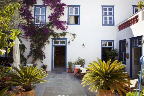 a courtyard of a house with purple flowers at Ippokampos in Hydra