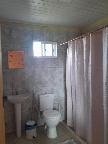 baño con aseo y lavabo y ventana en Itsasoa, en Barra del Chuy