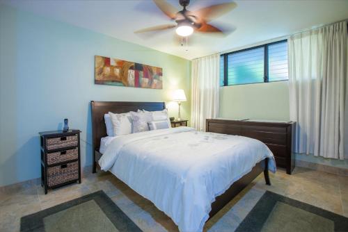 um quarto com uma cama e uma ventoinha de tecto em Maui Parkshore 105 - MCH em Kihei