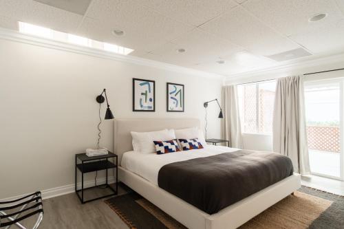 Un dormitorio blanco con una cama grande y una ventana en Balboa II by AvantStay Modern Condo w Balcony Views of Balboa Park, en San Diego