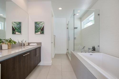 een badkamer met een bad, een wastafel en een douche bij Polo Villa 1 by AvantStay Features Expansive Pool, Spa & Outdoor Firepit 260-322 5 Bedrooms in La Quinta