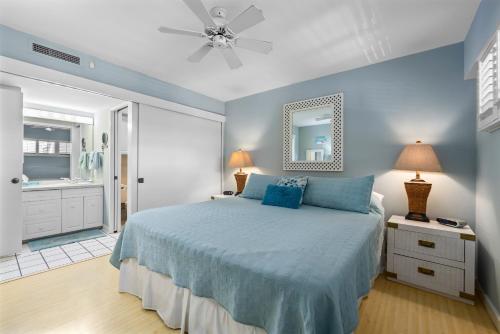 a blue bedroom with a bed and a bathroom at Sugar Beach 306 - MCH in Kihei