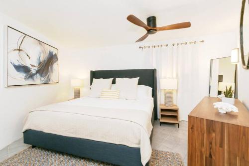 - une chambre avec un lit et un ventilateur de plafond dans l'établissement Town Walk, Beach Steps, Sea View, à Enighed
