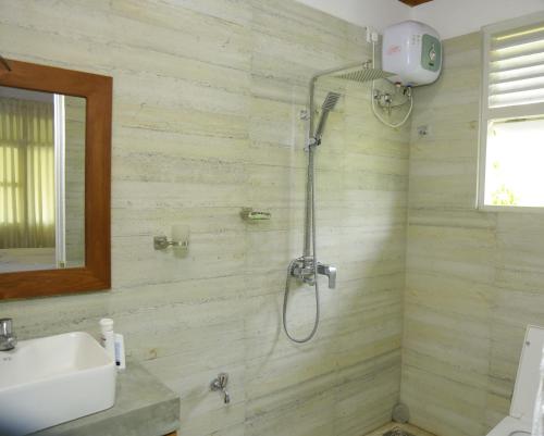 a bathroom with a shower and a sink at Serenity Villa Anuradhapura in Anuradhapura