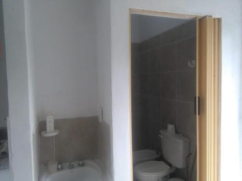 a bathroom with a toilet and a tub and a sink at Casa de campo en la ciudad in Chumillo