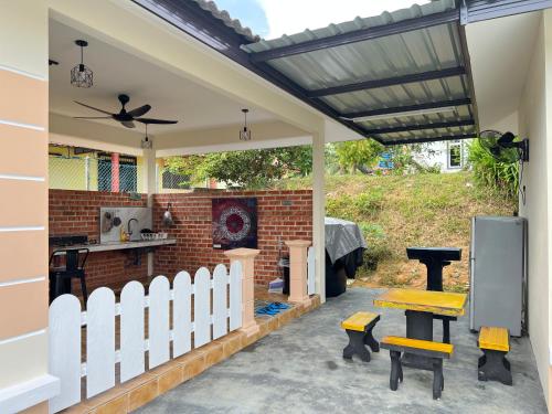 a patio with a white fence and a brick fireplace at AA SWEET ROOM TANJUNG BIDARA MELAKA in Masjid Tanah