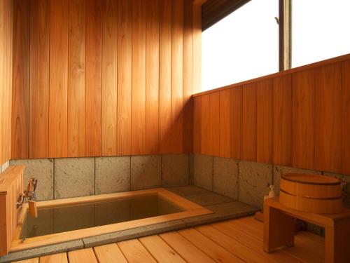a bath room with a tub and a toilet at Musashino Bekkan in Hakone