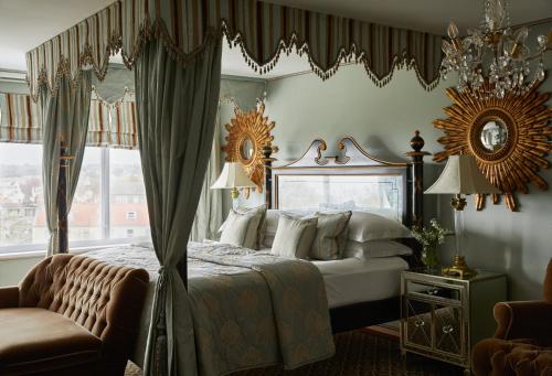 a bedroom with a canopy bed and a window at Duke Of Richmond Hotel in St. Peter Port