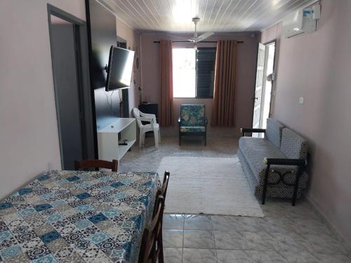 a room with a bed and a couch and a tv at Casa disponível para diária, 300m do mar casa sozinha no terreno in Matinhos