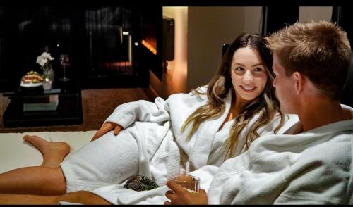 a woman laying in a bed next to a man at Amarè Beachside Luxury in Turners Beach