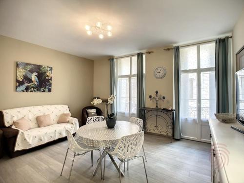 un salon avec un canapé, une table et des chaises dans l'établissement Appartement F3 avec Wifi et Parking proche Thermes, animaux acceptés à Lamalou-les-Bains - FR-1-451-122, à Lamalou-les-Bains