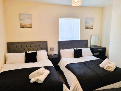 a bedroom with two beds with towels on them at Luxury house for 6 guests next to Anfield stadium in Liverpool