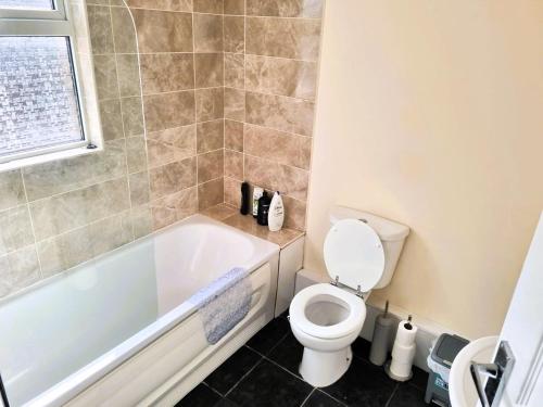 a bathroom with a white tub and a toilet at Luxury house for 6 guests next to Anfield stadium in Liverpool