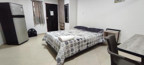 a bedroom with a bed with a black and white comforter at Genial Loft Tipo Smart San Alonso in Bucaramanga