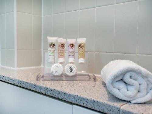 a bathroom counter with a towel and some products on it at Haven -79 in Perranwell
