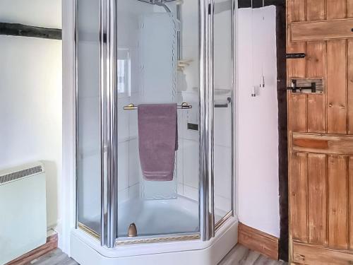 a glass shower with a purple towel in a bathroom at Hive Mews in Abingdon