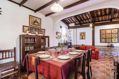 uma sala de jantar com uma mesa com uma toalha de mesa vermelha em Villa Vegent-All equipped Retreat em Antigua Guatemala