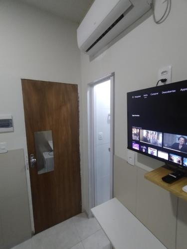 a room with a flat screen tv on a wall at Mini suíte Atitude Maragogi Centro in Maragogi