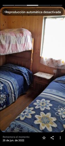 1 dormitorio con 2 camas y ventana en Hostal kenita, en Constitución