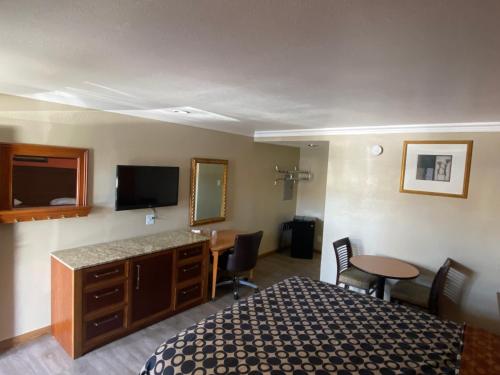 a hotel room with a bed and a desk and a television at Downtown Motel 7 in San Bernardino