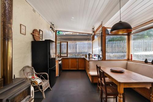 a kitchen with a table and a dining room at The True Heart of Uraidla Villa in Uraidla