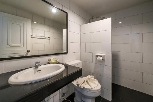 y baño con lavabo, aseo y espejo. en Tiya House Rooms & Cafe, en Krabi