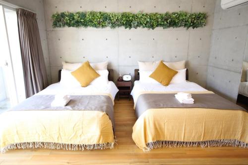 a bedroom with two beds and a wall with plants at TAKETO STAY OSAKAJO 9F - Vacation STAY 09349v in Osaka