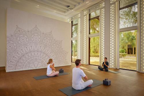 a group of people sitting in a yoga class at The Ritz-Carlton Ras Al Khaimah, Al Wadi Desert in Ras al Khaimah