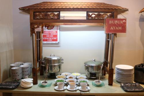 a buffet with cups and plates on a table at Swiss-Belinn Malang in Malang