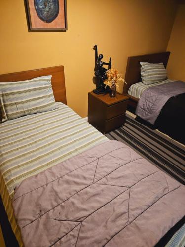 a bedroom with two beds and a table with flowers at Tidy Queens Apartment in Queens