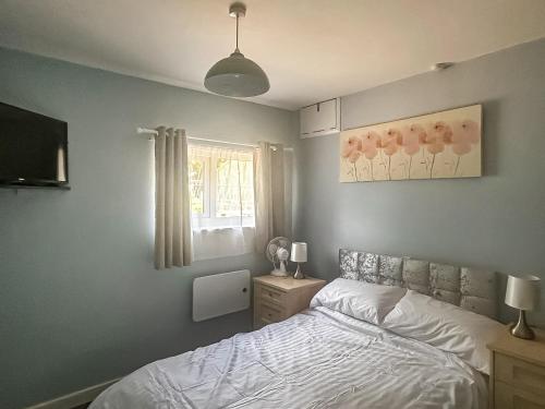 a bedroom with a bed and a window at The Lodge in Pauntley