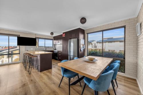a kitchen and dining room with a table and chairs at Capri Apartments in Merimbula