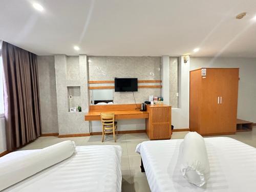 Habitación de hotel con 2 camas y escritorio en Rich Hotel en Can Tho