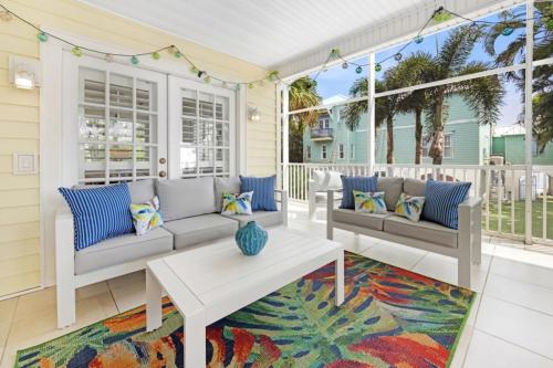a patio with two couches and a table on a porch at Turtle Cottage home in Captiva