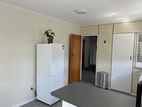 a kitchen with a white refrigerator and a door at Parkview Holiday Homes "Opposite of Famous Kuirau Park" in Rotorua