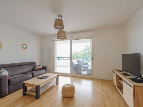 un salon avec un canapé et une table dans l'établissement Appartement Calme avec Grande Terrasse, Aytré, Proche Lac, 2 Pers. - FR-1-535-49, à Aytré