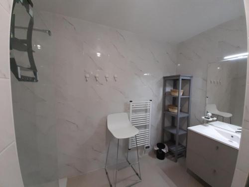 une salle de bains blanche avec un comptoir blanc et un tabouret dans l'établissement Charmant appartement neuf à Capbreton avec balcon, Wifi, et parking sécurisé pour 5 personnes - FR-1-239-1004, à Capbreton