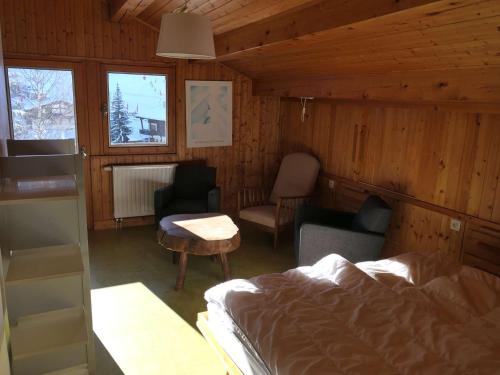 une chambre avec un lit, une table et des chaises dans l'établissement Appartement typique 75m², 2 chambres, balcon, face au télésiège, parking, proche front de neige. - FR-1-595-92, à Notre-Dame-de-Bellecombe