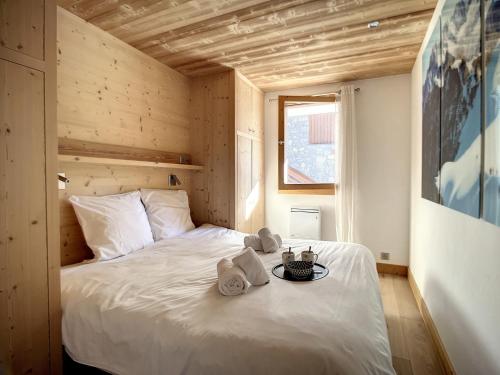 a bedroom with a white bed with towels on it at Appartement chaleureux Rénové Grand balcon Vue montagne - FR-1-688-67 in Méribel