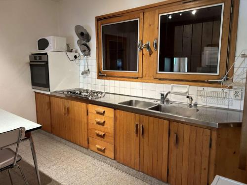 une cuisine avec un évier et un micro-ondes dans l'établissement Chalet spacieux 8 pièces, 14 personnes, prés des pistes, parking - FR-1-595-93, à Notre-Dame-de-Bellecombe